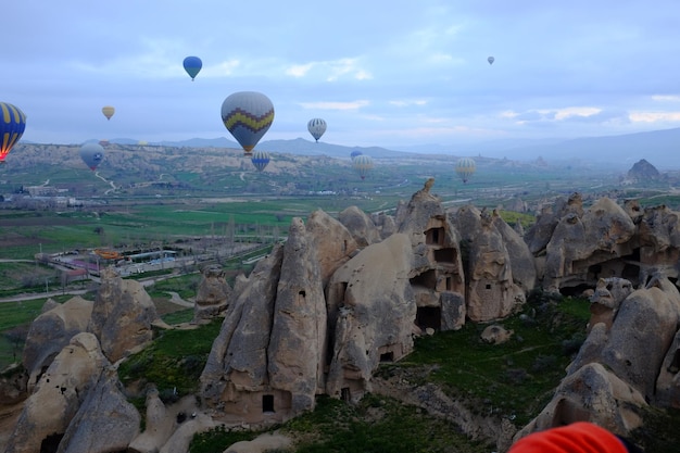 Una mongolfiera che vola sopra le montagne rocciose contro il cielo.