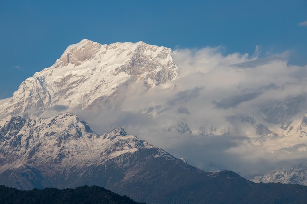 Una montagna con nuvole e un cielo blu