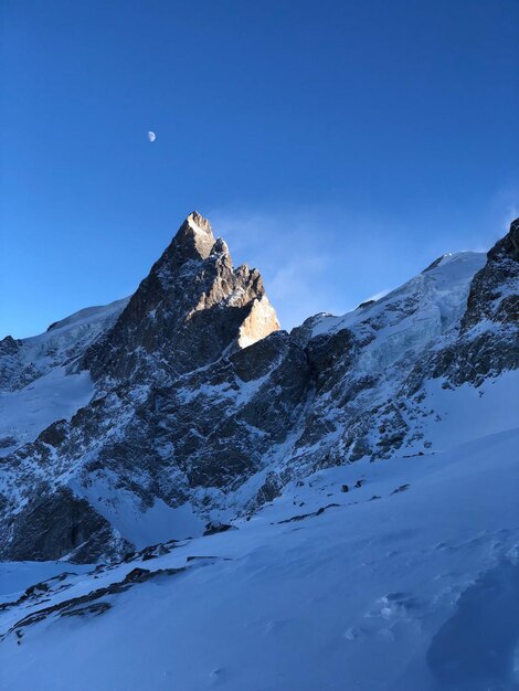 Una montagna con una luna nel cielo