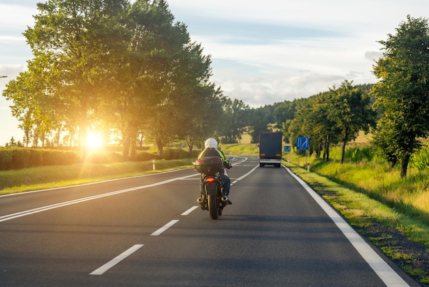 Una moto sta guidando lungo l'autostrada con un camion davanti