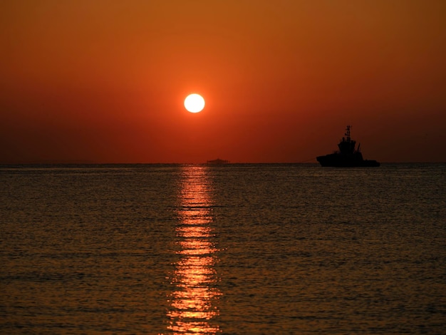 Una nave in partenza dal porto all'alba