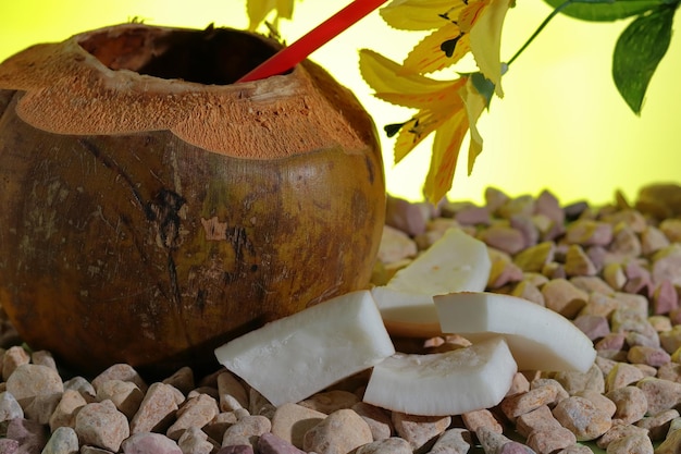 Una noce di cocco con una cannuccia e alcuni pezzi di cocco