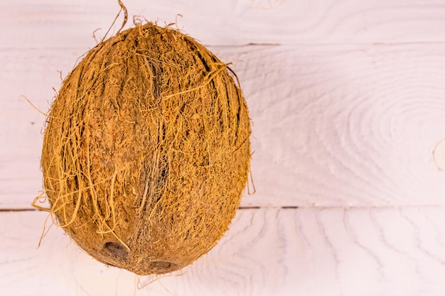 Una noce di cocco intera su un tavolo di legno Vista dall'alto