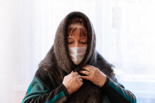 Una nonna anziana con una mascherina medica chirurgica e un velo