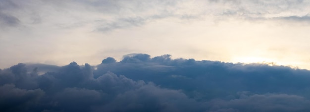 Una nube di tempesta scura in fondo al cielo illuminato dal sole serale