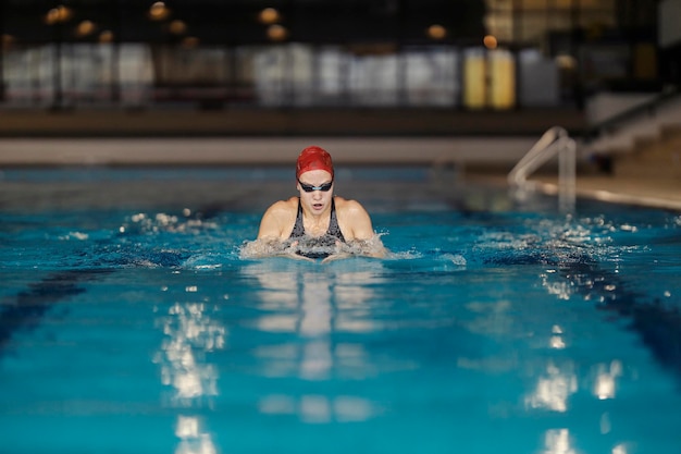 Una nuotatrice professionista sta nuotando nella piscina olimpica