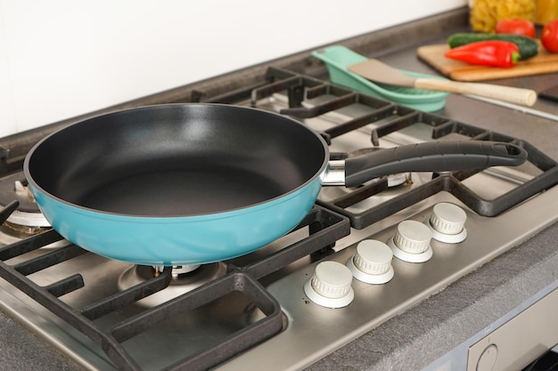 Una nuova padella sul fuoco e le verdure fresche si trovano vicino alla padella sul piano di lavoro