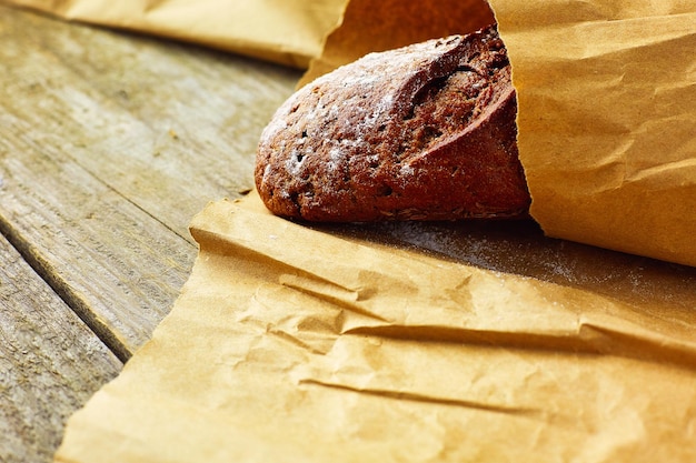 Una pagnotta di pane confezionata in carta su un tavolo di legno