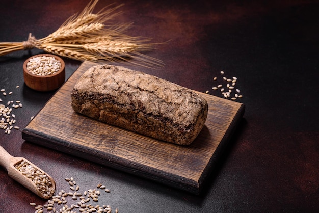 Una pagnotta di pane integrale con chicchi di cereali su un tagliere di legno