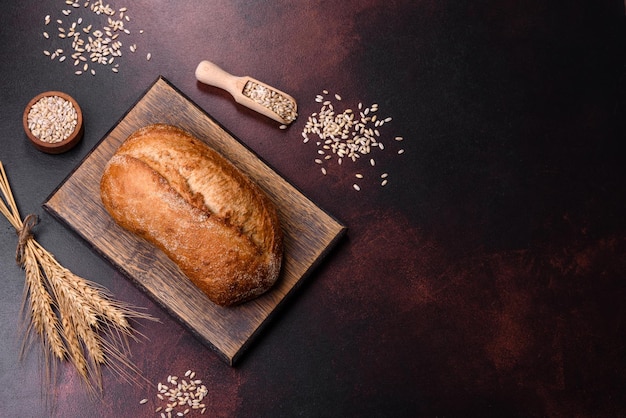 Una pagnotta di pane integrale con chicchi di cereali su un tagliere di legno