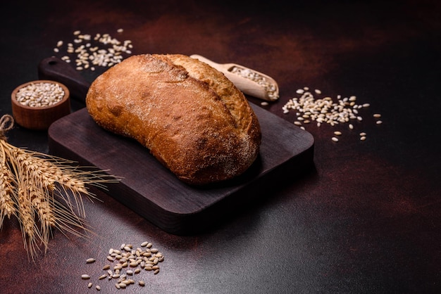 Una pagnotta di pane integrale con chicchi di cereali su un tagliere di legno