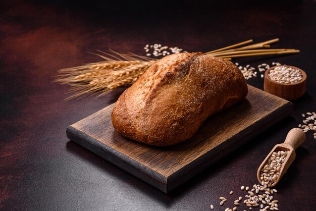 Una pagnotta di pane integrale con chicchi di cereali su un tagliere di legno