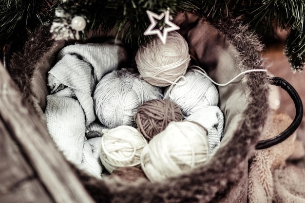 Una palla di filo per maglieria si trova sotto l'albero di Natale. Accogliente concetto di sera d'inverno. Foto