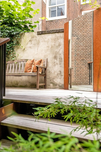 Una panca di legno su un patio con un muro di mattoni