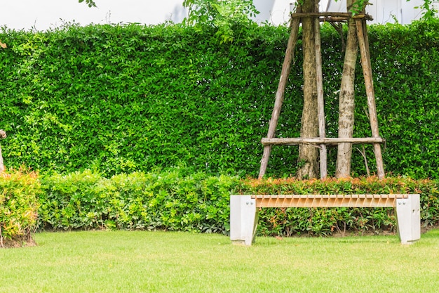 Una panca di pietra sotto un albero con lo sfondo della natura in un giardino.