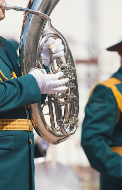 Una parata di strumenti a fiato un uomo in costume verde che suona la tuba