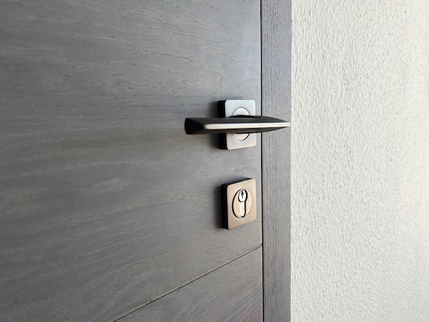 Una parte della porta in legno rovere grigio con serratura e maniglia in metallo