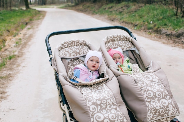 Una passeggiata nel parco con due gemelli in un passeggino doppio