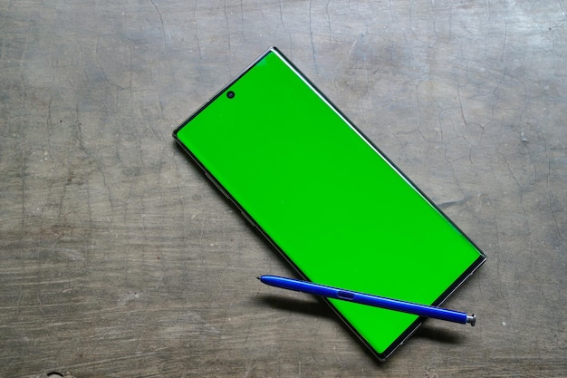 Una penna blu si trova su un tavolo accanto a una penna blu e una penna verde.