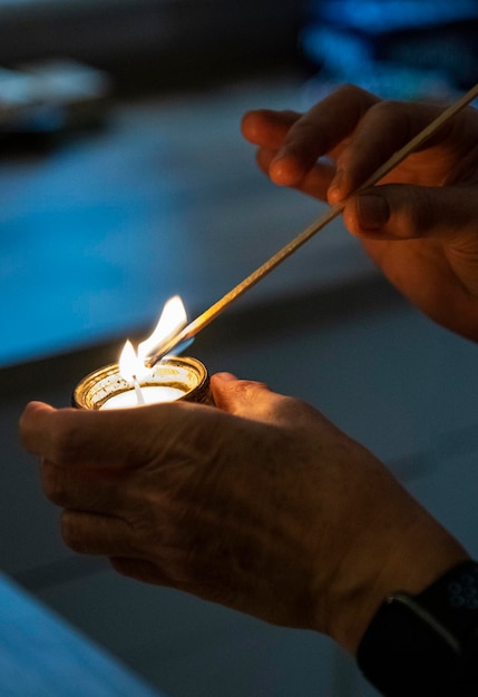 una persona che accende una candela con un lungo fiammifero