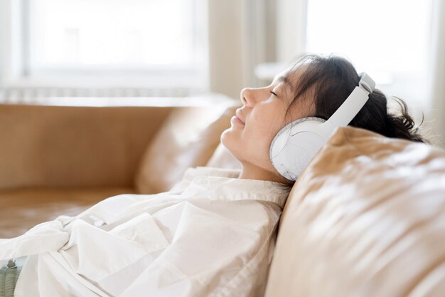 Una persona che ascolta comodamente la musica di una playlist di audiolibri di podcast preferiti con le cuffie