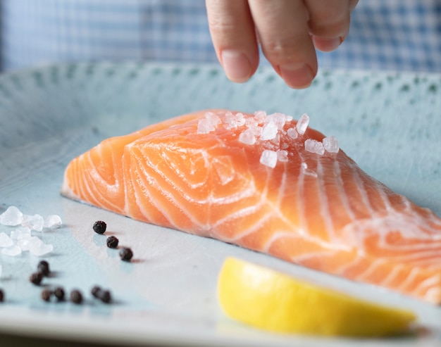 Una persona che condisce un filetto di salmone