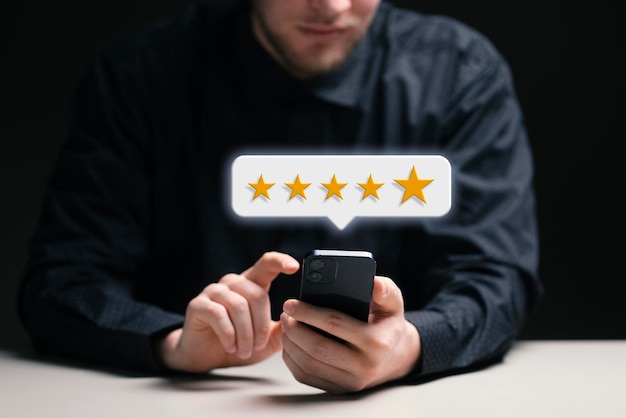 Una persona che dà una valutazione a cinque stelle online in possesso di un concetto di recensione del cliente per smartphone