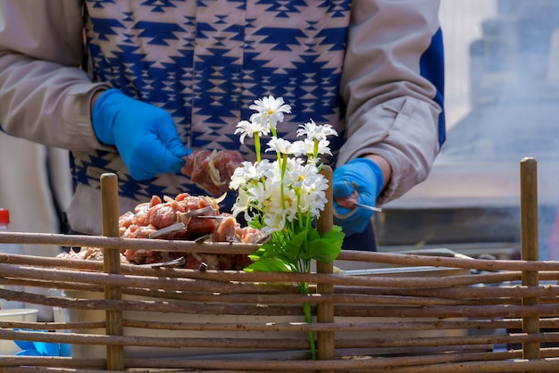 Una persona che indossa guanti blu tiene dei fiori in un cesto.