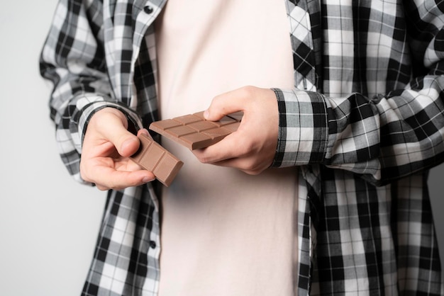 Una persona che tiene e frena una barretta di cioccolato nero