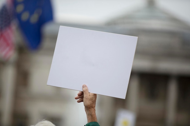 Una persona che tiene uno striscione di protesta in bianco durante una manifestazione politica