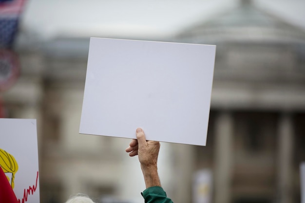 Una persona che tiene uno striscione di protesta in bianco durante una manifestazione politica