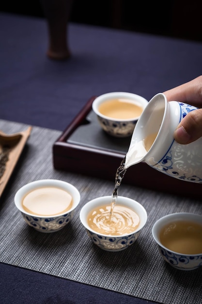 Una persona che versa una tazza di caffè in una piccola ciotola.