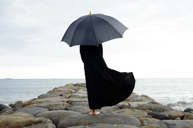 Una persona con ombrellone in spiaggia