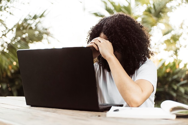 Una persona con stress davanti a un laptop