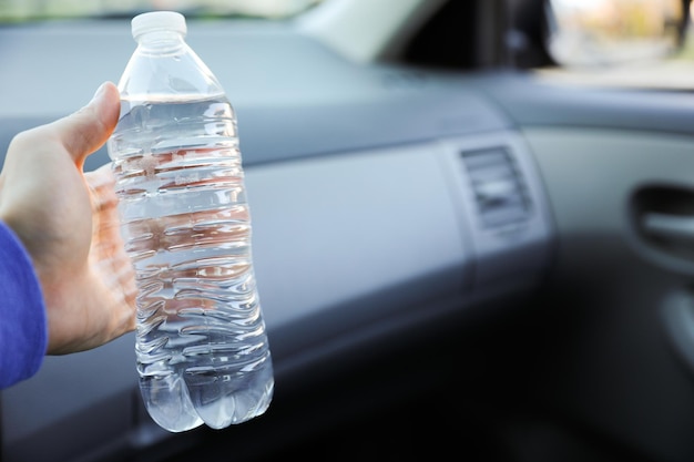Una persona con una bottiglia d'acqua in macchina