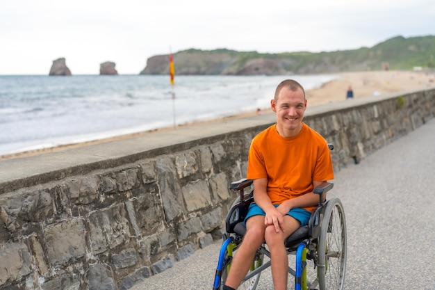 Una persona disabile in sedia a rotelle sulla spiaggia che si diverte in estate