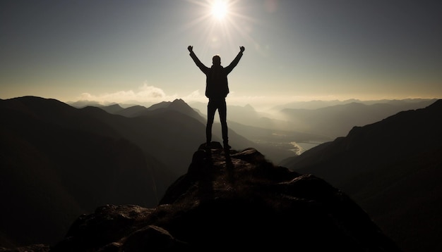 Una persona in cima a una montagna con il sole che splende sulle braccia