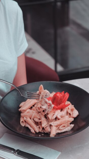 una persona sta mangiando una ciotola di cibo con una forchetta