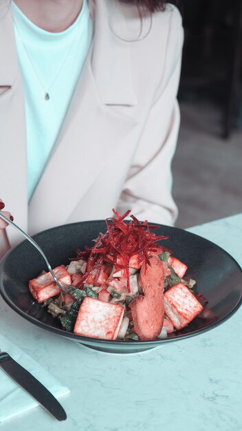 una persona sta mangiando una ciotola di cibo con una forchetta