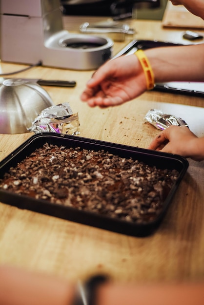 Una persona sta mettendo il cibo in una padella con sopra la parola cioccolato.