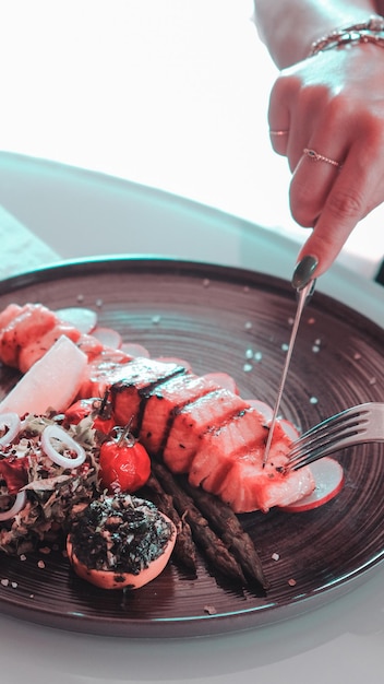 una persona sta tagliando il cibo su un piatto con una forchetta