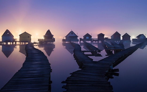 una piccola casa di legno con un tramonto sullo sfondo