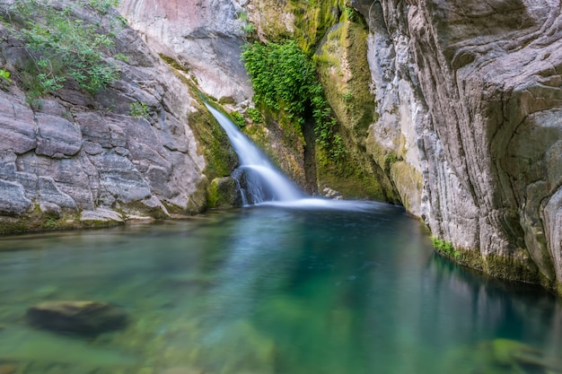 Una piccola cascata pittoresca in un'accogliente laguna di montagna