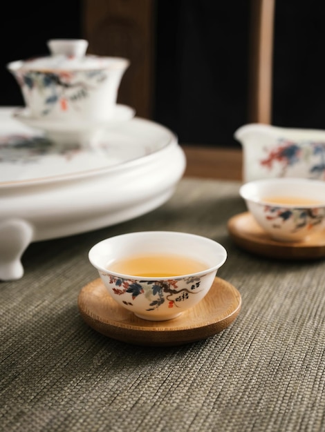 Una piccola ciotola di tè si trova su un tavolo con un vassoio bianco con su scritto "tè".