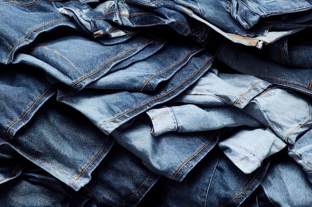 Una pila di blue jeans è mostrata con uno dei jeans a sinistra