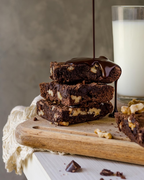 Una pila di brownies al cioccolato e noci con cioccolato fuso che cade