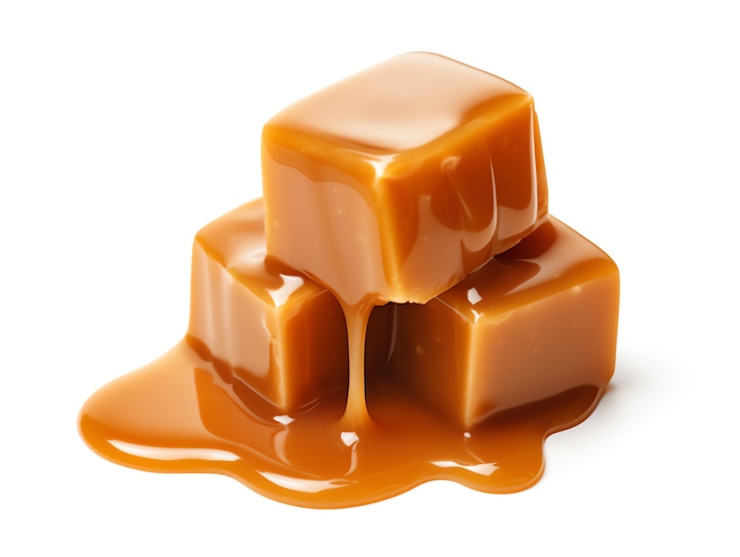 Foto una pila di caramelle al caramello con liquido che scorre