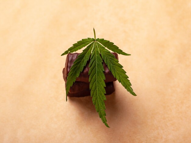 Una pila di cioccolatini con una foglia di marijuana medica, dolci con cannabis.