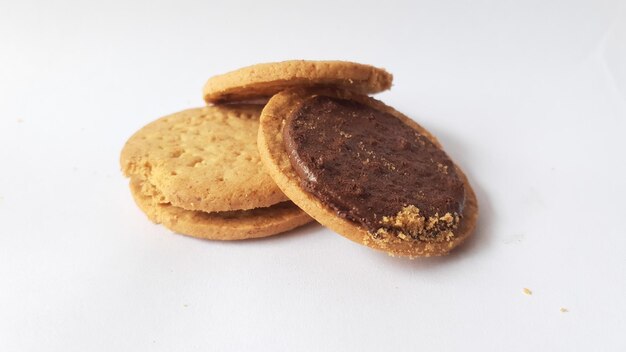 Una pila di deliziosi biscotti rotondi di grano con ripieno di cioccolato isolato su sfondo bianco