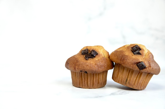 Una pila di deliziosi muffin alla banana con scaglie di cioccolato e mirtilli su uno sfondo bianco gustosa salute